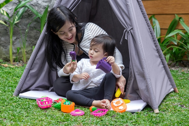 Jouez aux jouets avec la mère dans la tente