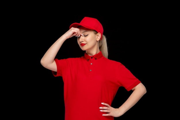 Jour de chemise rouge fille fatiguée avec les yeux fermés dans un bonnet rouge portant une chemise avec du rouge à lèvres