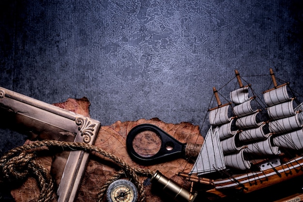 Jour de Colomb. Pirates et trésor avec carte du monde et équipement de découverte. Copiez l'espace sur fond sombre.