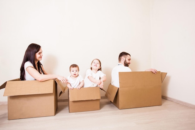 Jour de déménagement et jeux familiaux dans des boîtes en carton dans une nouvelle maison