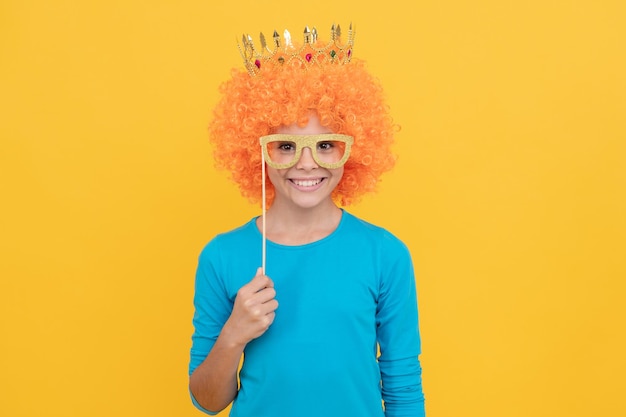 Jour du poisson d'avril enfance heureuse fête d'anniversaire des filles joyeux enfant drôle en perruque frisée et couronne imaginez-vous une reine joyeuse enfant porter diadème adolescente dans des lunettes de fête étant un clown