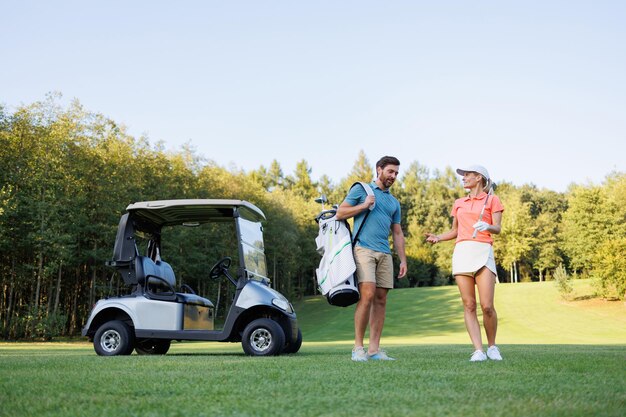 Photo un jour ensoleillé, un couple joue au golf sur le green.