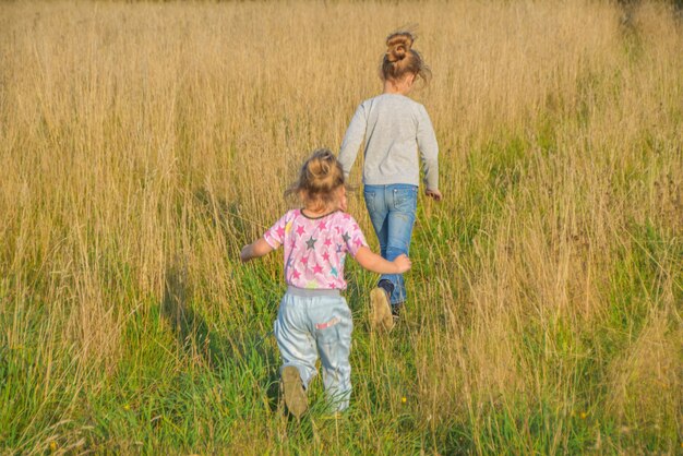 Le jour d'été ensoleillé, un enfant court autour du champ avec du seigle