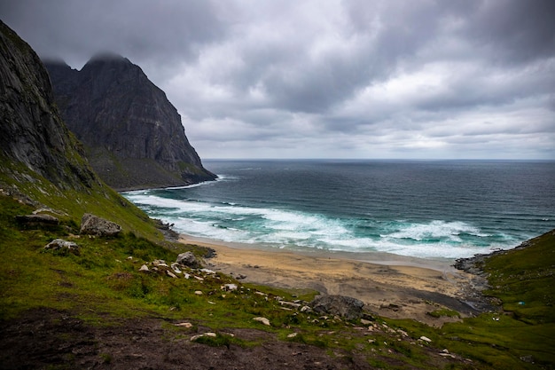 jour nuageux sur la plage de kvalvika dans les îles lofoten, norvège, célèbre plage entourée de montagnes majestueuses