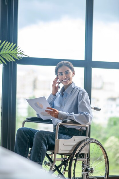 Jour ouvrable. Une jeune femme handicapée parlant au téléphone