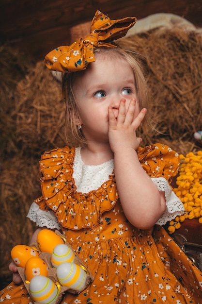 Photo le jour de pâques famille se préparant pour pâques girl holding basket avec des oeufs peints sur un motif en bois