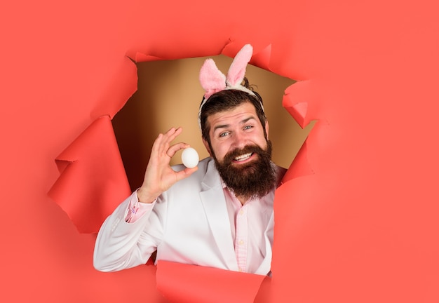 Jour de pâques heureux homme barbu détient oeuf de pâques vacances de printemps costume de lapin de pâques lapin de printemps