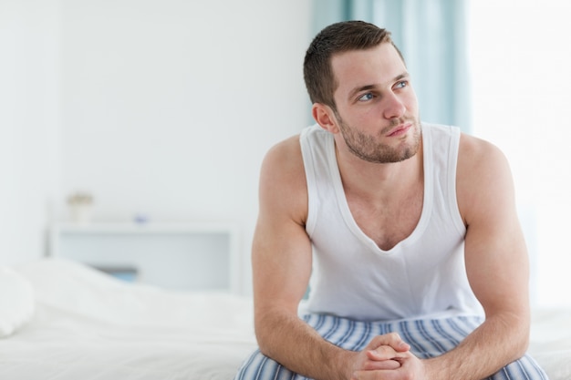 Photo jour rêvant d'un homme assis sur son lit