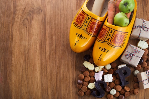 Jour de saint nicolas sinterklaas avec carotte de chaussure et bonbons traditionnels sur fond de bois