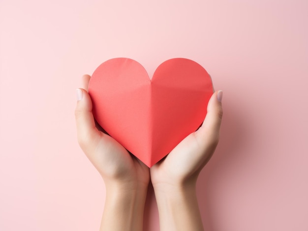Le jour de la Saint-Valentin, des cœurs rouges en papier sont tenus dans la main dans l'amour.