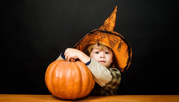 Photo jour de thanksgiving cuisine enfant garçon avec citrouille halloween enfant avec jackolantern surpris enfant dans