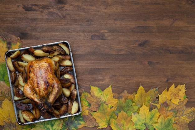 Jour de Thanksgiving avec un délicieux poulet grillé sur fond de feuilles d'automne et récolte de citrouille.