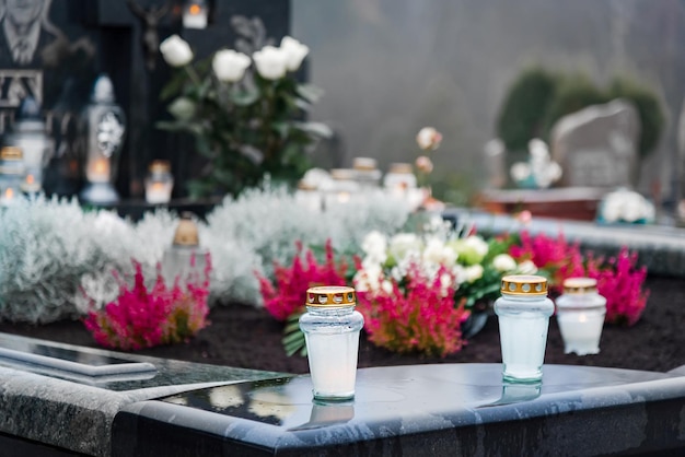 Jour de tous les saints et allumage de bougies et de fleurs sur les tombesLes bougies sur les tombeaux symbolisent la mémoire des morts le 1er novembreCimetière catholique pendant la fête de tous les SaintsFocus sélectif