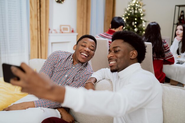 Le jour de la veille de noël, la famille dîne ensemble deux frères assis sur le canapé