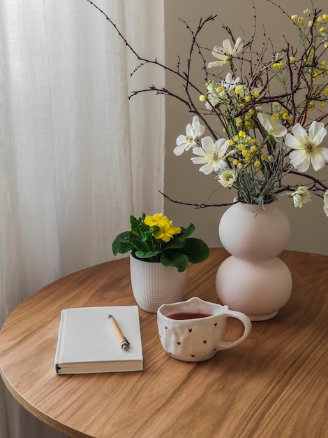 Un journal de gratitude une tasse de fleurs de thé sur une table ronde en bois rituel quotidien concept de maison confortable