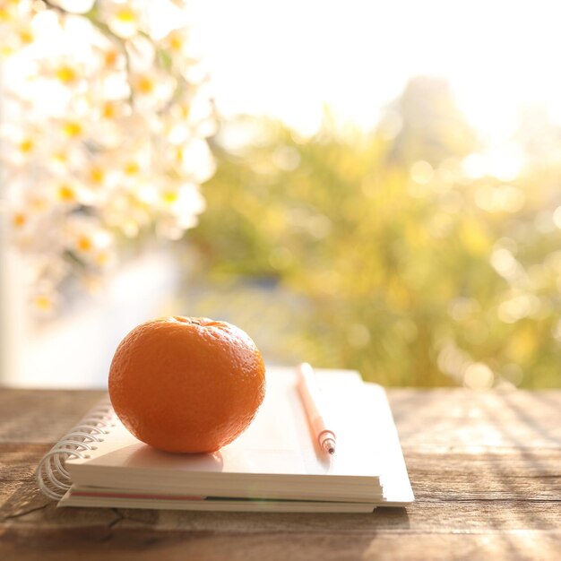 Journal orange et cahier sur table en bois