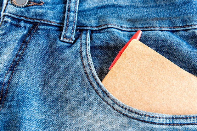 Journal avec stylo rouge dans la poche de jeans