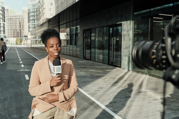 Journaliste africain avec micro diffusion en direct sur rue