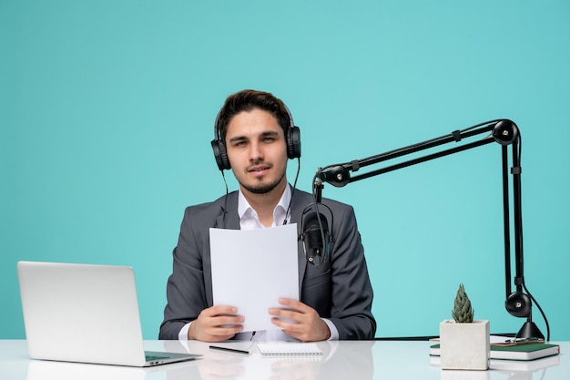 Journaliste blogueur enregistrant une vidéo mignon beau mec au bureau tenant un script