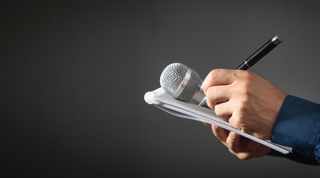 Journaliste caucasien tenant un bloc-notes et un stylo de microphone