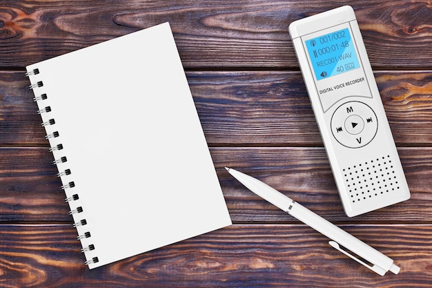 Photo journaliste enregistreur vocal numérique ou dictaphone, bloc-notes vierge et stylo sur une table en bois. rendu 3d