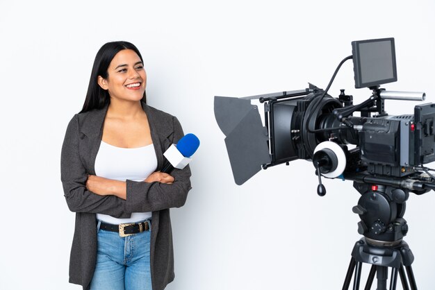 Journaliste femme colombienne tenant un microphone et rapportant des nouvelles sur blanc