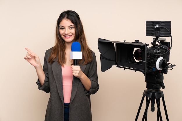 Journaliste femme tenant un microphone et rapportant des nouvelles sur le mur pointant le doigt sur le côté