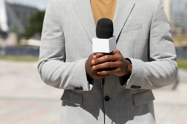 Photo journaliste homme vue de face tenant un microphone