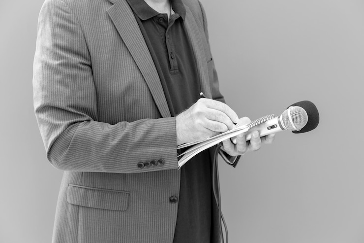 Photo journaliste ou journaliste de télévision lors d'une conférence de presse ou d'un événement médiatique tenant un microphone et écrivant des notes