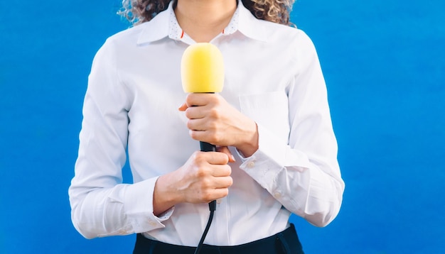 Journaliste tenant un journaliste de microphone jaune et un concept de nouvelles