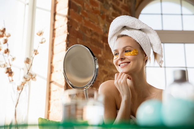 Journée de la beauté Femme portant une serviette faisant sa routine quotidienne de soins de la peau à la maison