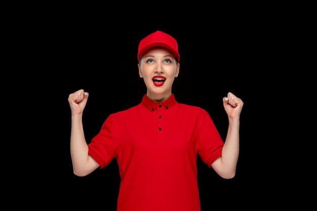 Journée de la chemise rouge femme heureuse tenant les poings dans un bonnet rouge portant une chemise avec du rouge à lèvres