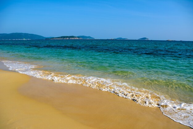 Journée ensoleillée, craquement de sable, mer turquoise claire, récifs coralliens sur la côte de la baie de Yalong en mer de Chine méridionale. Sanya, île de Hainan, Chine. Paysage naturel.