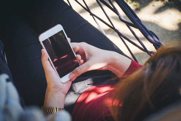 Une journée ensoleillée d&#39;une jeune femme tenant et utilisant un smartphone