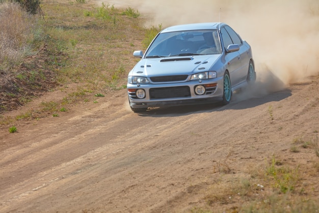 Journée d'été ensoleillée. Piste de rallye poussiéreuse. La voiture de sport fait beaucoup de poussière à son tour 02