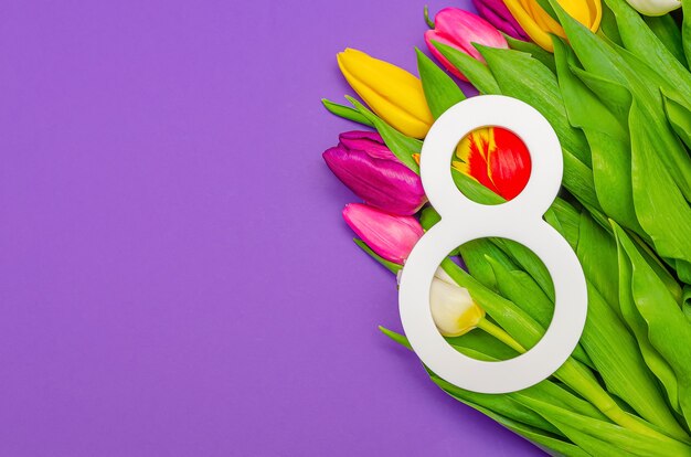 Journée de la femme, 8 mars, félicitations, fleurs sur fond coloré, place pour le texte. Convient pour la publicité, les cartes postales, les félicitations. Espace de copie