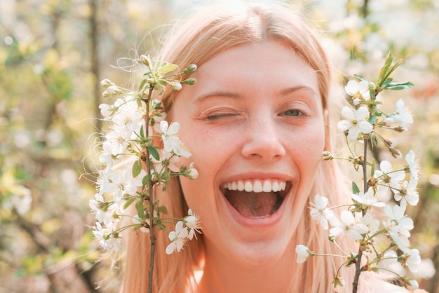 Journée de la femme 8 mars Funny portrait of blonde woman on spring flowers pattern Close up