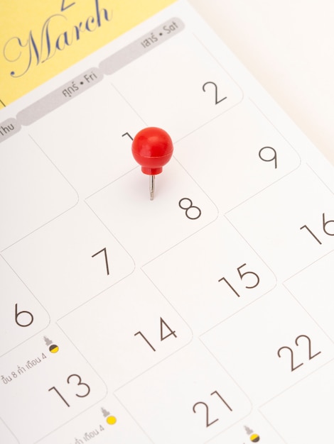 Photo journée de la femme au calendrier avec une épingle rouge.