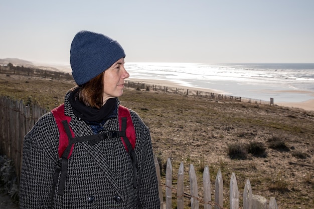 Journée d'hiver femme avec sac à dos cap à la mer océan atlantique lors d'une visite à pied de la plage