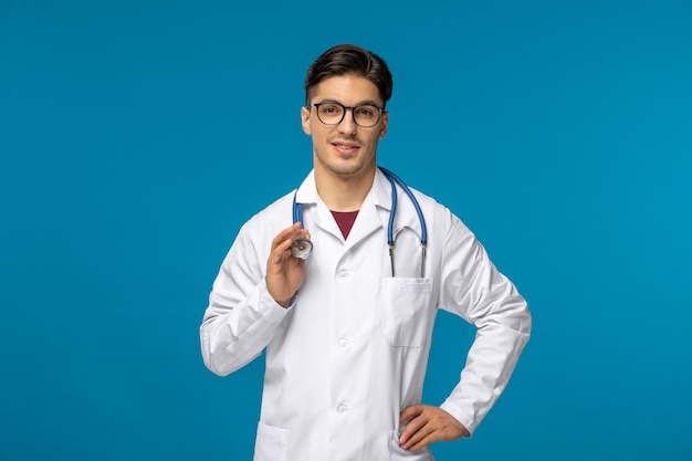 Journée des médecins beau mec mignon brune en blouse médicale tenant un stéthoscope