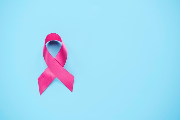 Journée mondiale du cancer et concept de journée du cancer du sein, symbole de sensibilisation ruban rose sur fond bleu. Le cancer est la cause de la mort humaine numéro un dans le monde en raison du mode de vie, de la nourriture et de l'hérédité.