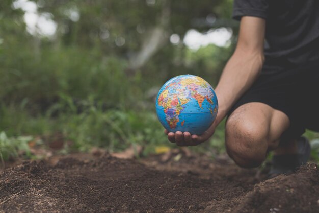 Photo journée mondiale de l'environnement aime le monde la main tenant un globe