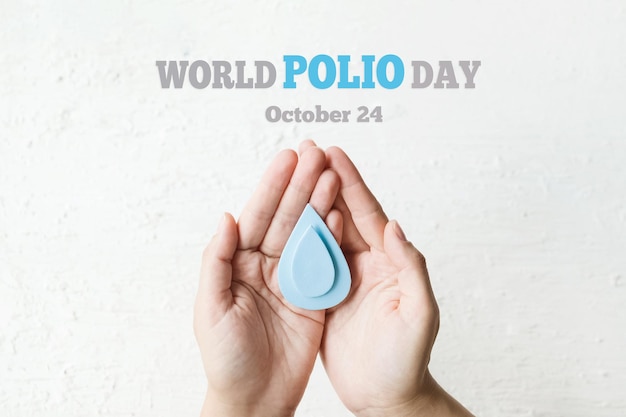 Journée mondiale de la polio 24 octobre La goutte bleue dans les mains d'un adulte est le symbole du vaccin contre la polio