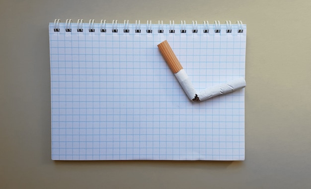 Journée mondiale sans tabac, Journée sans tabac. Cigarette cassée sur un cahier d'affaires, place pour votre texte.