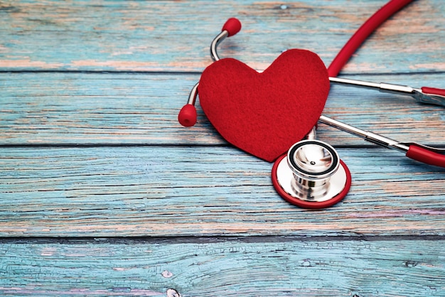 Photo journée mondiale de la santé, concept de santé et médical, stéthoscope rouge et coeur rouge sur le fond en bois bleu