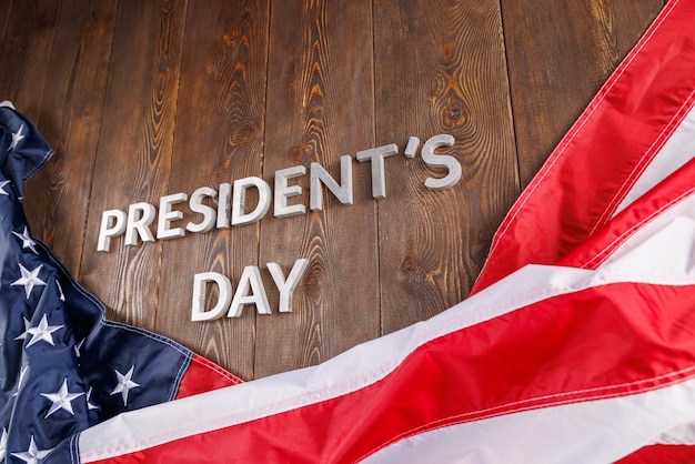 Journée des présidents de mots posée avec des lettres d'argent sur une surface en bois près du drapeau américain