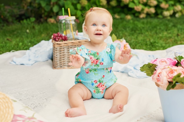 Journée de la protection des enfants, une petite fille dans le parc est assise dans un panier lors d'un pique-nique estival