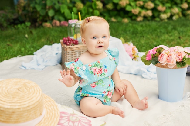 Photo journée de la protection des enfants, une petite fille dans le parc est assise dans un panier lors d'un pique-nique estival