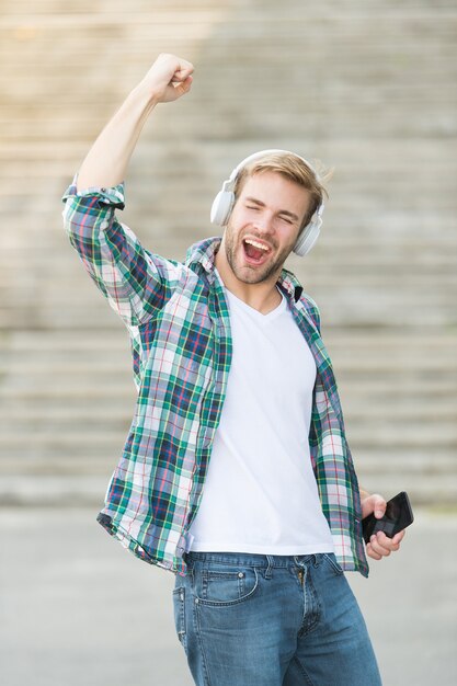 Journée réussie. Éducation en ligne. Concept de livre audio. Technologie educative. étudiant e apprentissage. vie scolaire. Écouter de la musique. Jeunesse moderne et numérique. l'homme heureux a passé des examens. téléphone d'écouteurs d'étudiant.