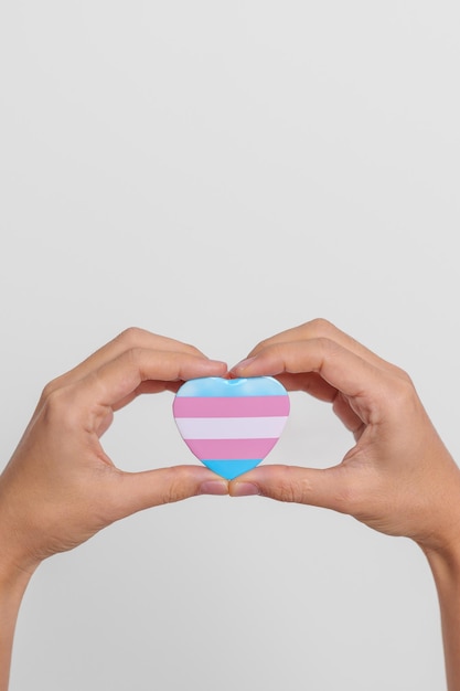 Journée des transgenres et mois de la fierté LGBT Concept LGBTQ ou LGBTQIA main tenant une forme de coeur bleu rose et blanc pour la communauté lesbienne gay bisexuelle transgenre queer et pansexuelle